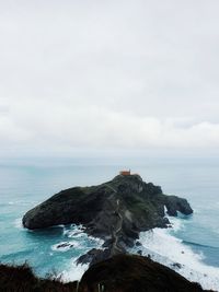 Lighthouse by sea against sky