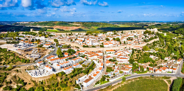 High angle view of townscape by sea against sky