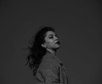 Low angle view of woman with eyes closed against sky