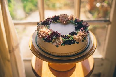 Close-up high angle view of flowers on cake on table at home