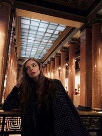 Portrait of beautiful woman standing in corridor
