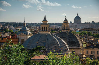 Overview of trees, cathedrals domes and roofs of buildings in rome. italy.