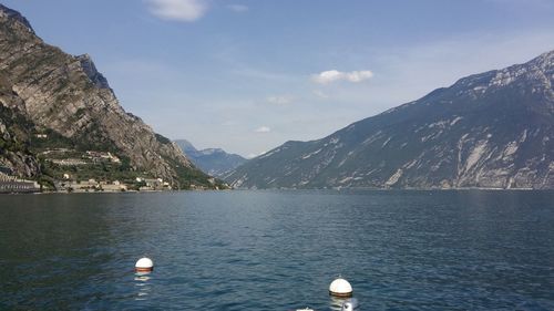 Scenic view of sea by mountains against sky