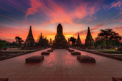 Temple by building against sky during sunset