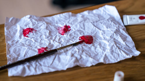High angle view of heart brush on table on paper