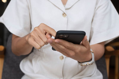 Midsection of man using mobile phone
