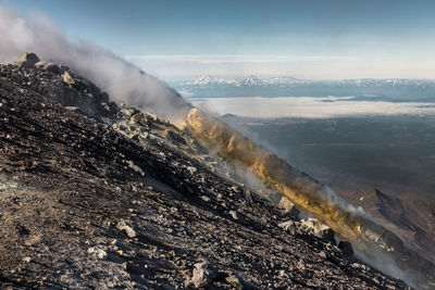 Smoke emitting from volcanic mountain against sky