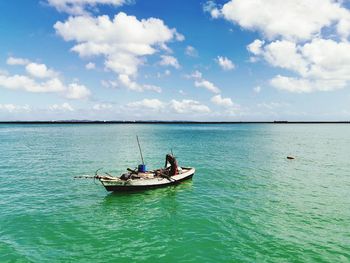 Fishing boat in sea against sky