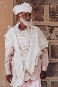 Midsection of man standing against wall