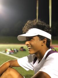 Side view of young athlete looking away at illuminated stadium