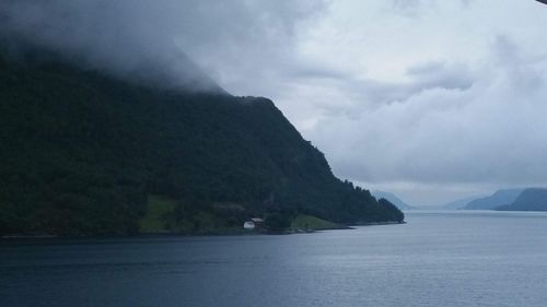 Scenic view of sea and mountains against sky