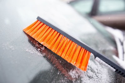 Winter problems with the car. a man cleans the car from snow with a brush