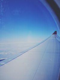 Close-up of airplane wing against blue sky