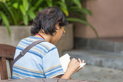 Rear view of boy holding book