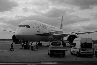 Airplane on airport runway against sky