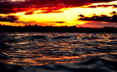 Surface level of sea against sky during sunset