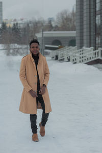 Young african american in winter against the backdrop of a majestic building