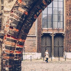 Woman walking by historic building
