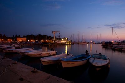 Boats moored in harbor at night