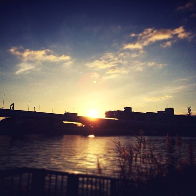 sunset, sun, water, sky, built structure, reflection, architecture, sunlight, silhouette, building exterior, cloud - sky, orange color, river, sunbeam, transportation, lens flare, beauty in nature, nature, scenics, waterfront