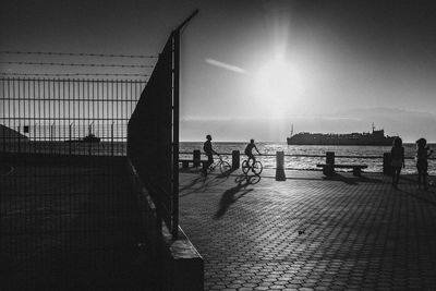 Silhouette people on beach against sky