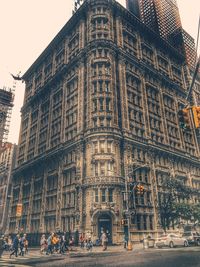 People on city street against buildings