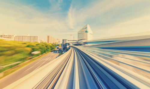 Blurred motion of train in city against sky