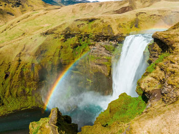 Famous skogafoss waterfall with a rainbow. dramatic scenery of iceland during sunset.