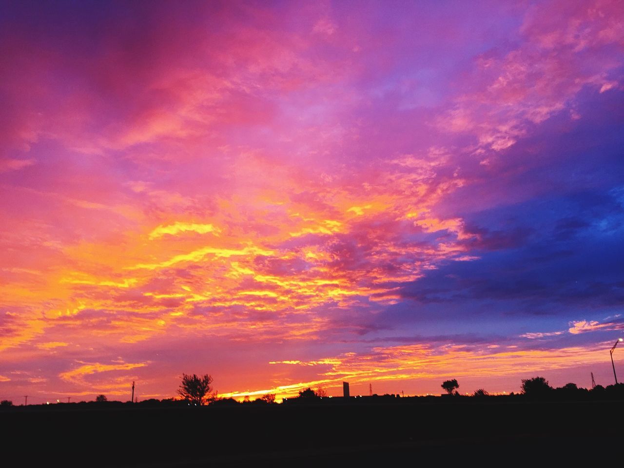 sunset, silhouette, sky, orange color, beauty in nature, scenics, cloud - sky, dramatic sky, tranquil scene, tranquility, cloud, nature, idyllic, moody sky, low angle view, cloudy, built structure, dark, landscape, outdoors