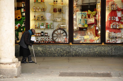 Side view of man walking outdoors store in city