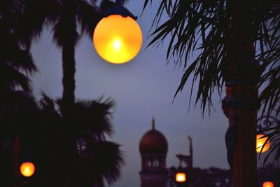 Low angle view of illuminated lantern against sky at night