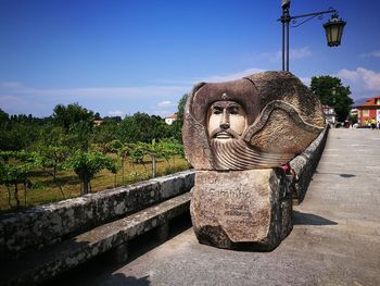 Statue in park against sky