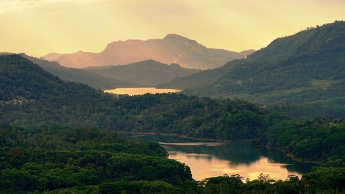 Scenic view of river and mountains against sky