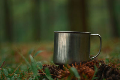 Close-up of coffee cup on field