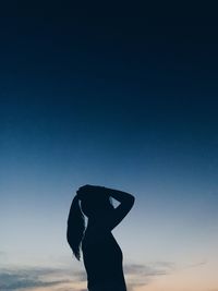 Silhouette woman standing against clear sky during sunset