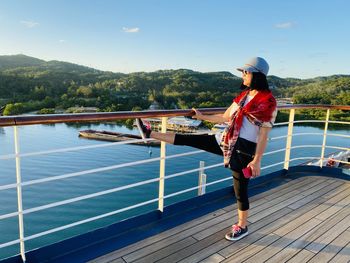 Woman standing on railing against mountain