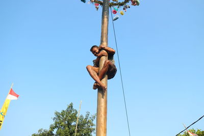 Low angle view of man against blue sky