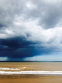 Scenic view of beach against cloudy sky