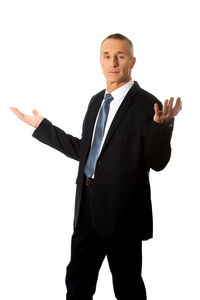 Portrait of businessman gesturing while standing against white background