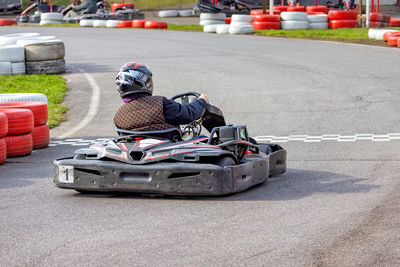 Racer skillfully navigates a winding go-kart track surrounded by vibrant red and white barriers.