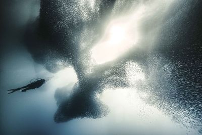 Man in sea against sky during winter