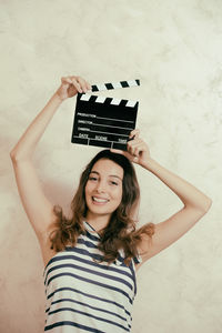 Portrait of smiling young woman against white background