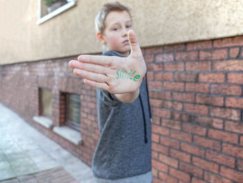 The word smile written on the palm of a boy