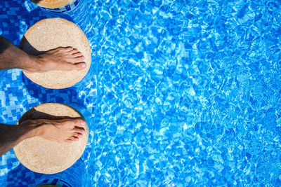 High angle view of man standing on stone amidst swimming pool