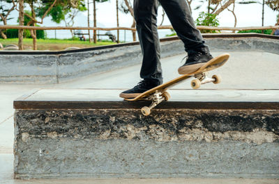 Skateboarder is doing a crooked grind trick on a bench in skatepark