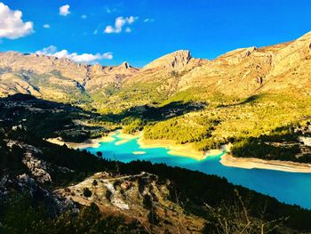 Scenic view of lake and mountains against blue sky