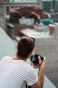 Rear view of woman photographing with mobile phone