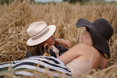 Woman wearing hat relaxing on field