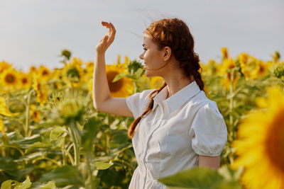 Side view of young woman holding flowers