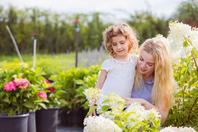 Cute girl smiling while standing by plants